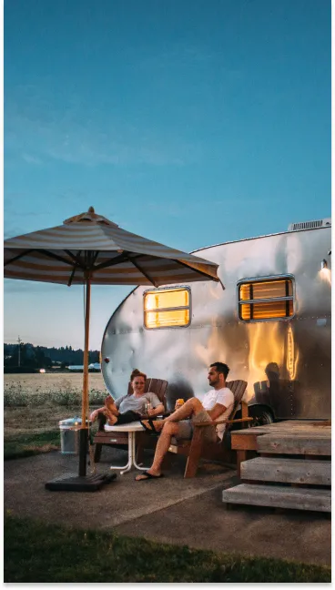 couple sitting outside of a camper