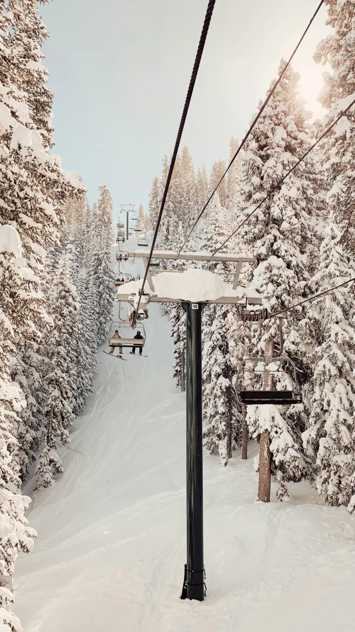 Two people on a chairlift in the distance