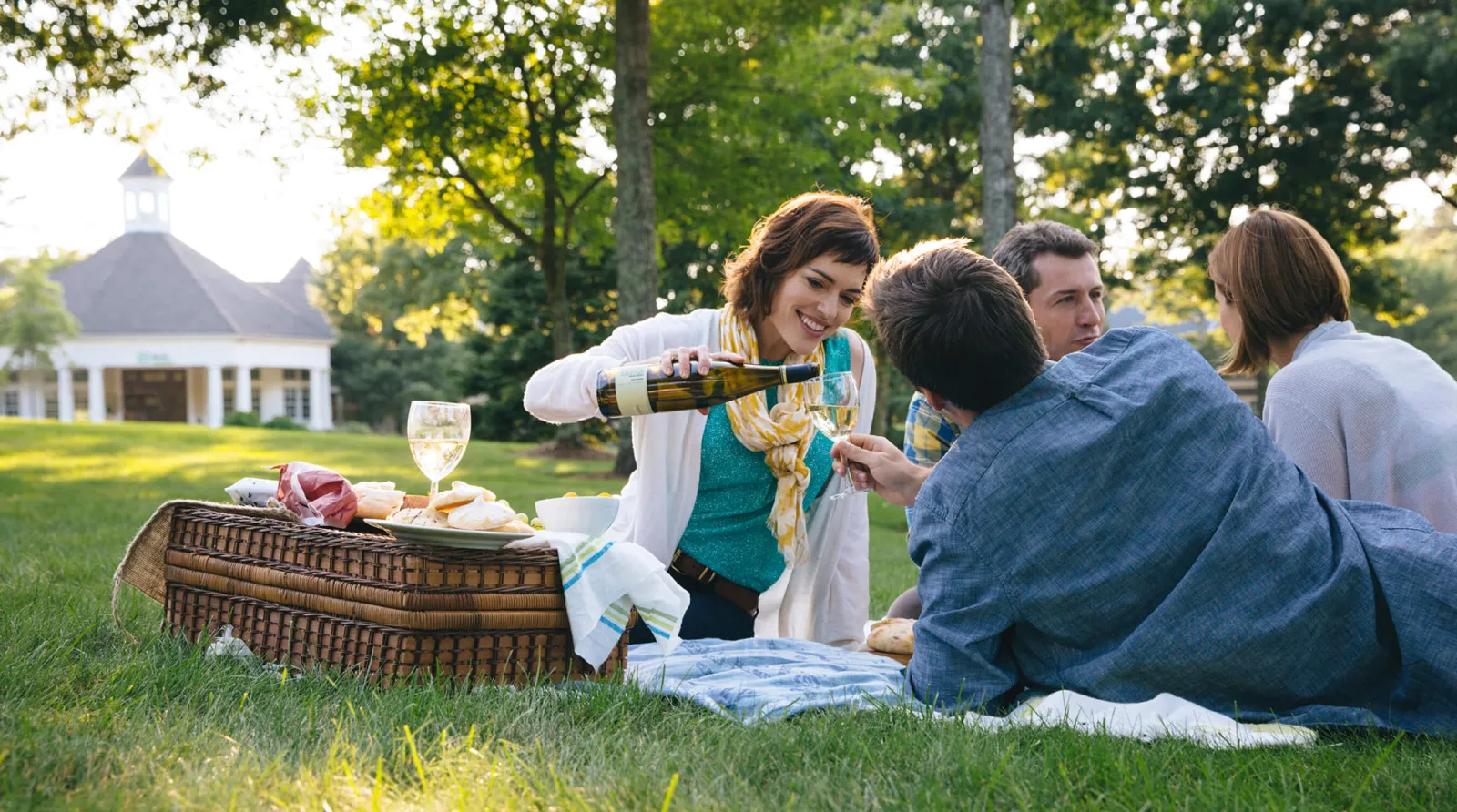 People drinking wine in front yard in the sun